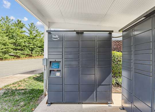 A grey Amazon Hub box is on the sidewalk.