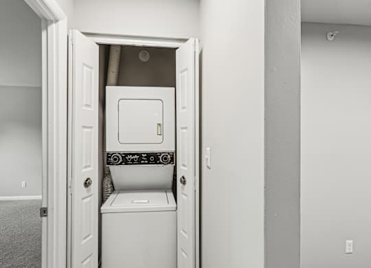 A white washing machine is installed in a small laundry room.
