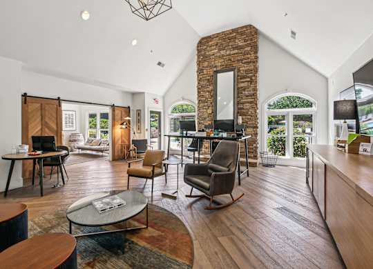 A living room with a brick fireplace and a large window at Elme Marietta Apartments, Marietta, GA
