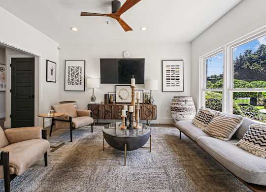 A living room with a large couch, a coffee table, and a ceiling fan  at Elme Marietta Apartments, Marietta, GA at Elme Marietta Apartments, Marietta, GA