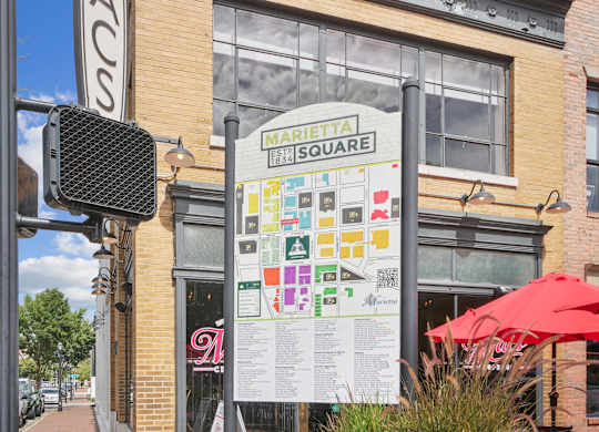A sign for Marietta Square is displayed on a pole in front of a building.