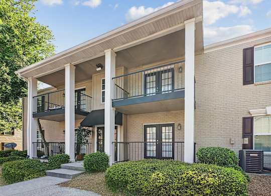 A two-story apartment building with a balcony on the second floor.