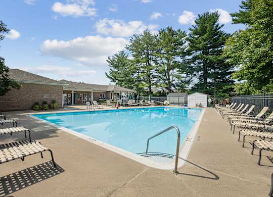 A large outdoor swimming pool surrounded by sun loungers.