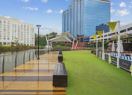 A long wooden boardwalk runs parallel to a body of water.