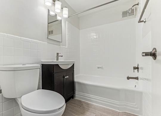 A white bathroom with a toilet, sink, and bathtub.