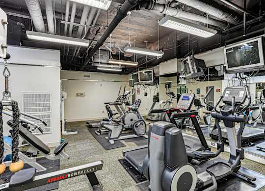 A gym with a variety of equipment including treadmills and exercise bikes.