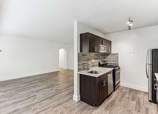 A kitchen with a sink, stove, and refrigerator.