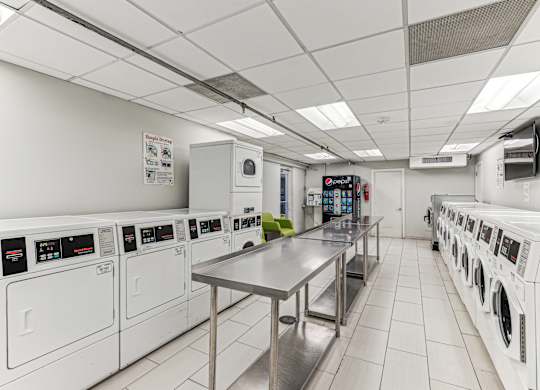 A laundromat with a row of washers and dryers.