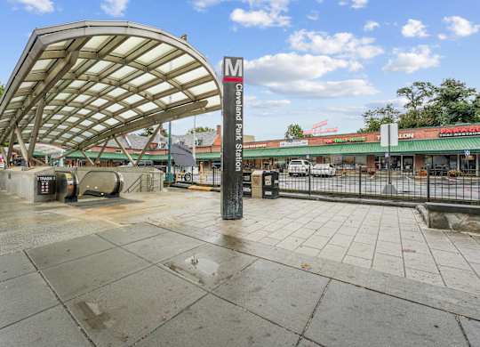 A wet sidewalk leads to a bus stop shelter.