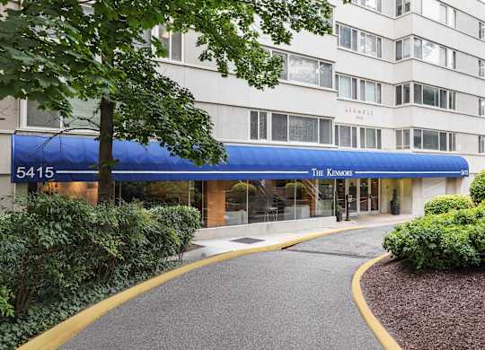 The entrance to The Kenmore apartment building is covered by a blue awning.
