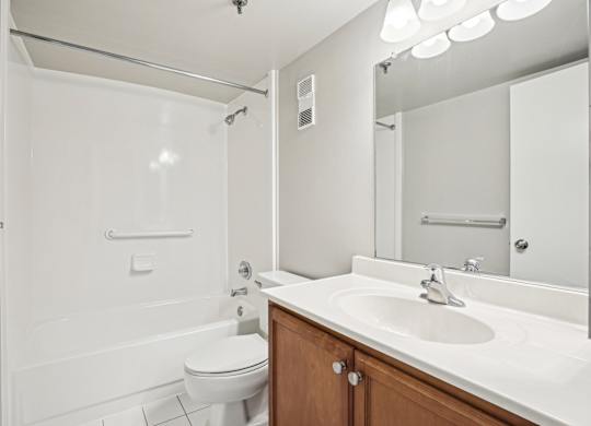 A white bathroom with a toilet, sink, and shower  at The Paramount, Arlington, Virginia