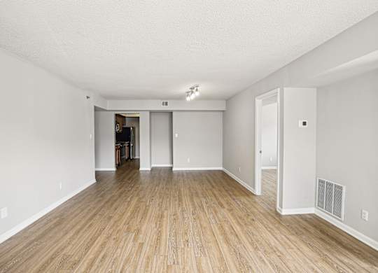 A room with wooden flooring and white walls.