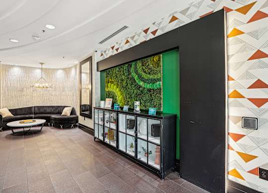 A modern living room with a black sofa and a glass cabinet.
