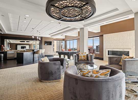 A modern living room with a large circular light fixture and grey couches.