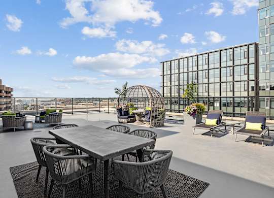 A table surrounded by chairs on a patio with a building in the background  at The Paramount, Arlington, Virginia