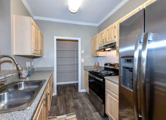 Kitchen with stainless steel appliances and wood cabinets at Elme Eagles Landing in Stockbridge, GA