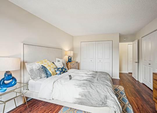 A bedroom with a bed, nightstand, and a lamp at Riverside Apartments, Alexandria, Virginia