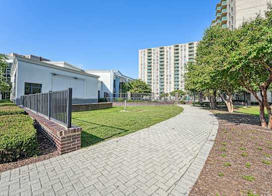 A walkway with a brick pattern leads through a grassy area at Riverside Apartments, Alexandria, Virginia