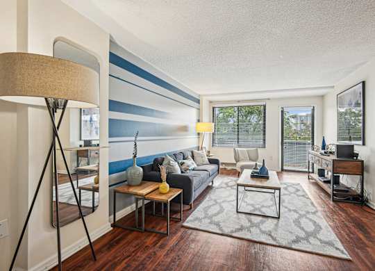 A living room with a grey sofa and a wooden coffee table at Riverside Apartments, Alexandria, Virginia