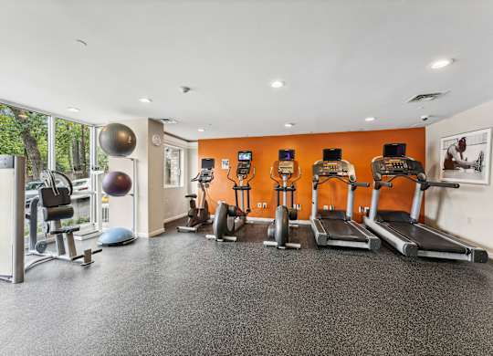A gym with orange walls and a variety of equipment  at Roosevelt Towers, Falls Church, VA