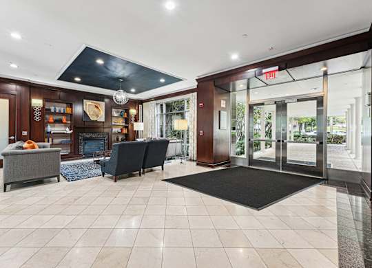 A spacious lobby with a black mat on the floor and a black couch  at Roosevelt Towers, Falls Church, VA