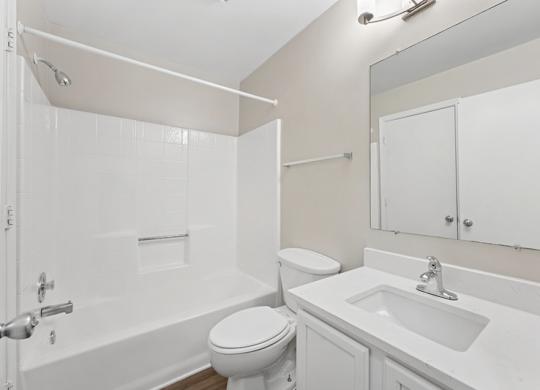 A white bathroom with a toilet, sink, and bathtub.