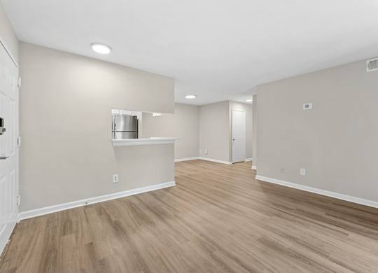A room with light wood flooring and white walls.