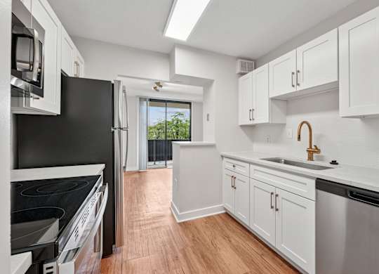 A kitchen with black appliances and white cabinets  at Riverside Apartments, Alexandria, Virginia