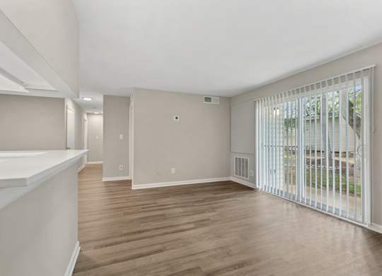 A spacious room with wooden floors and white walls.