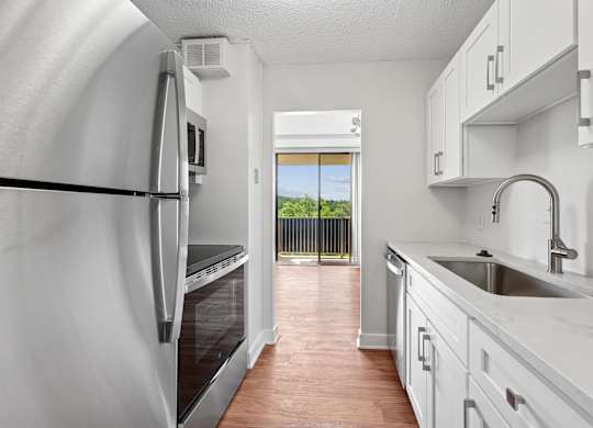 A kitchen with white cabinets and a stainless steel refrigerator  at Riverside Apartments, Alexandria, Virginia