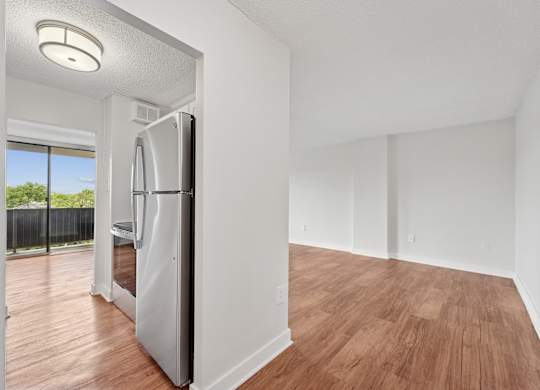 A modern kitchen with a refrigerator and wooden flooring  at Riverside Apartments, Alexandria, Virginia