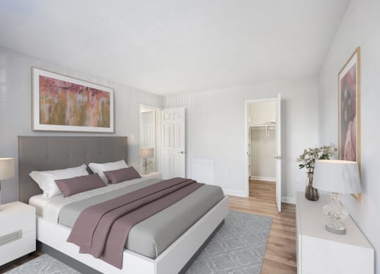 a bedroom with white walls and a bed with purple pillows at Roosevelt Towers, Falls Church, VA