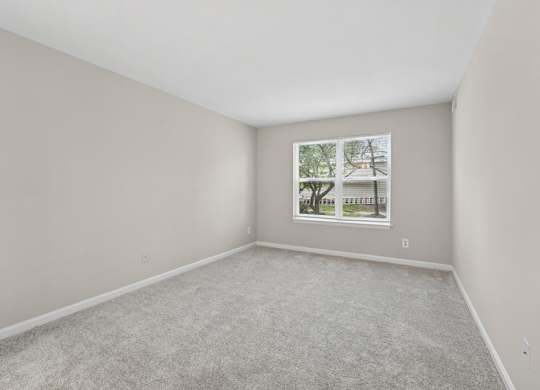 A room with a carpeted floor and a picture frame on the wall.