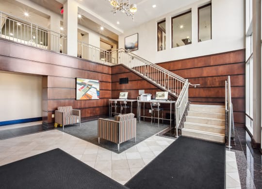 Lobby of a building with a staircase and chairs at Roosevelt Towers Apartments, Falls Church, Virginia