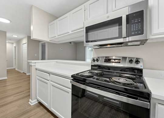 A modern kitchen with a stove and microwave oven.