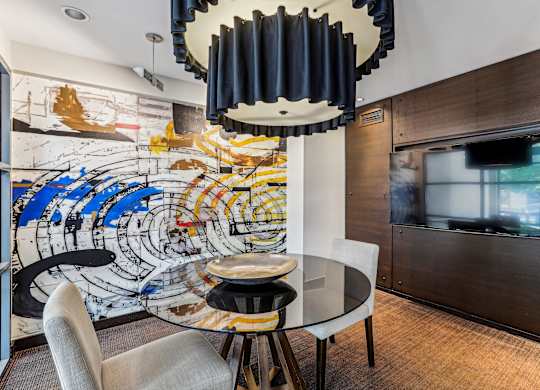 A modern dining room with a glass table and chairs at The Maxwell Apartments, Arlington