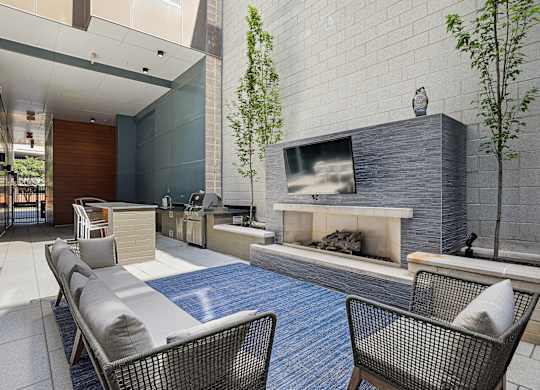 A patio with a fireplace and chairs at The Maxwell Apartments, Arlington