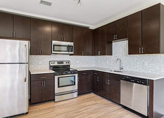 A kitchen with brown cabinets and white appliances.