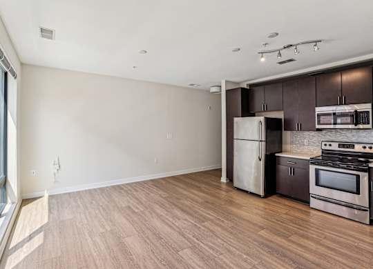 A kitchen with a refrigerator, oven, and microwave at The Maxwell Apartments, Arlington