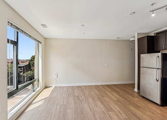 A kitchen with a refrigerator and wooden floors at The Maxwell Apartments, Arlington