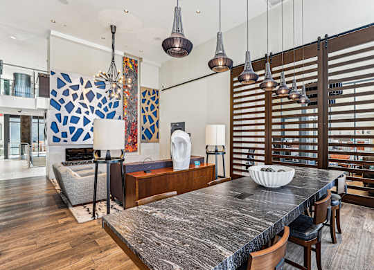 A modern kitchen with a large island and wooden chairs at The Maxwell Apartments, Arlington