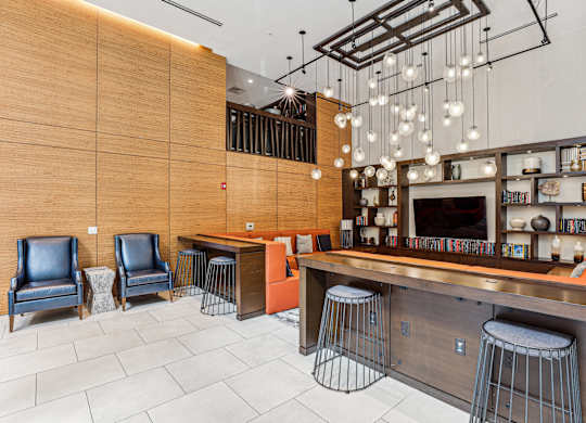 A bar area with a wooden counter and stools at The Maxwell Apartments, Arlington