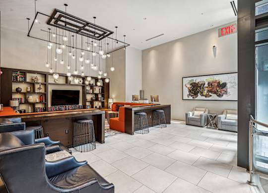 A modern living room with a bar area and a fireplace at The Maxwell Apartments, Arlington