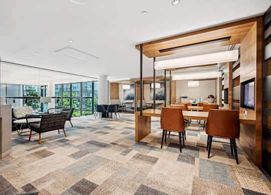 A modern office space with a large carpeted area and wooden accents.
