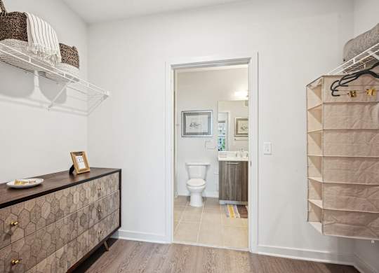 A bathroom with a toilet and a cabinet with a picture frame on top.