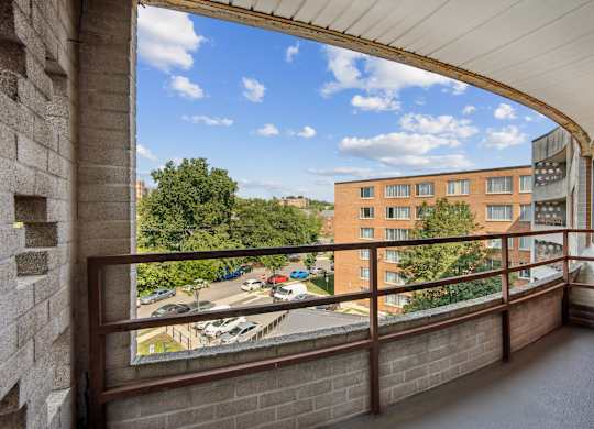 A balcony with a view of a parking lot and buildings at Wellington Apartments, Arlington, Virginia