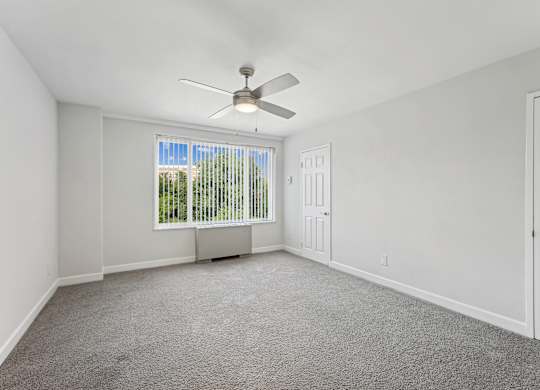 A room with a ceiling fan and a window with blinds at Wellington Apartments, Arlington, Virginia