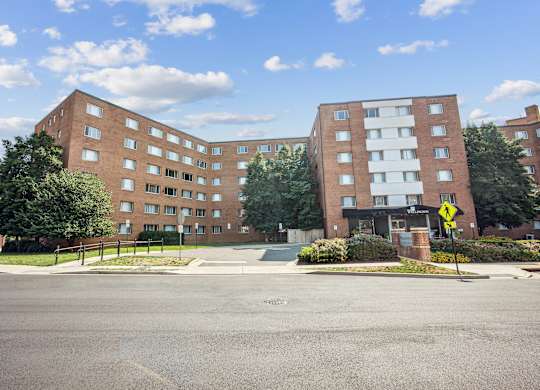 A street view of a residential area with two apartment buildings at Wellington Apartments, Arlington, Virginia