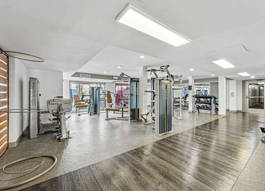 A gym with a variety of equipment including treadmills, weights, and exercise machines at Wellington Apartments, Arlington, Virginia