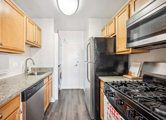 A kitchen with a black refrigerator and a black stove top oven at Wellington Apartments, Arlington, Virginia
